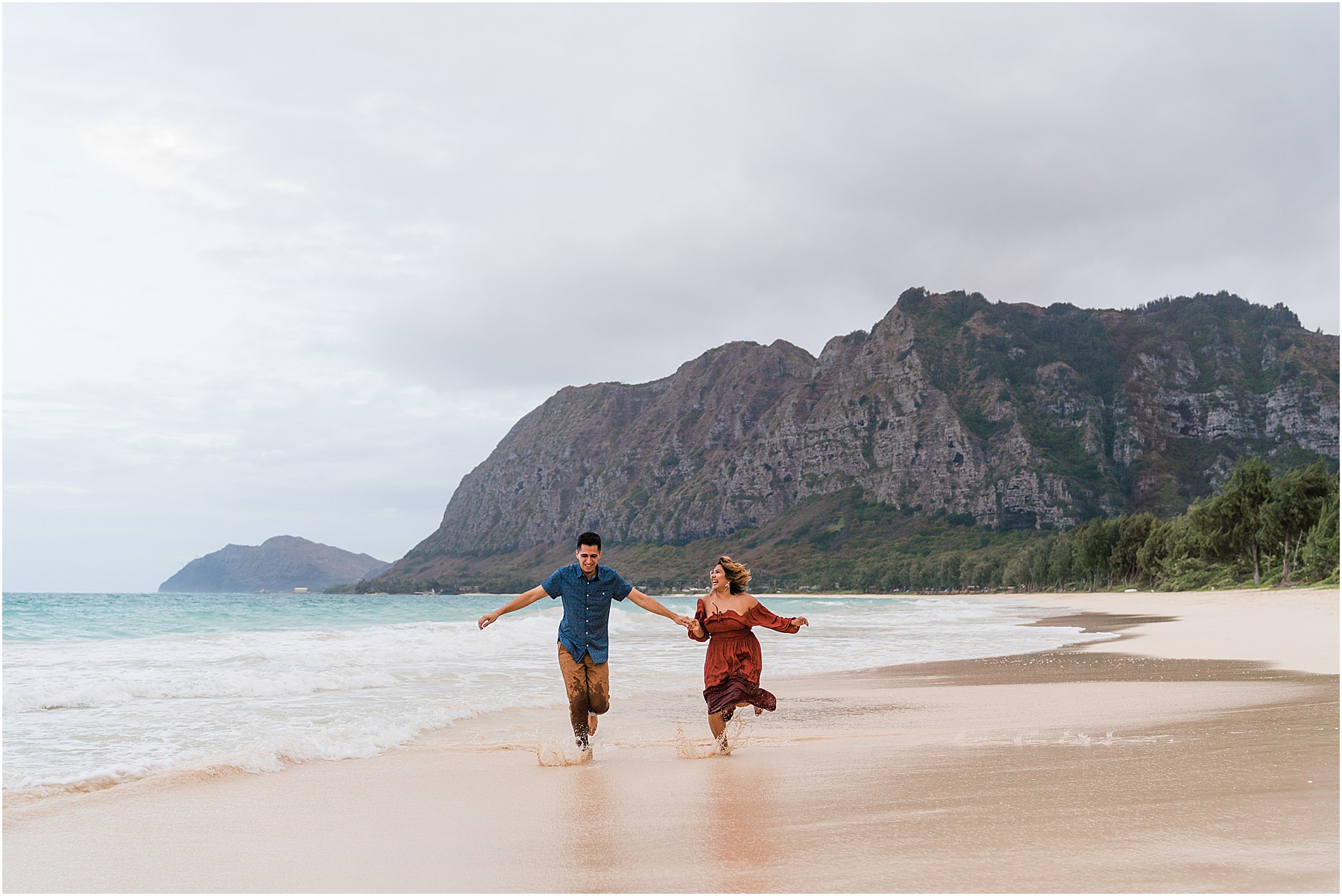 Couple frolicking on beach in Hawaii adventurous couples photo session