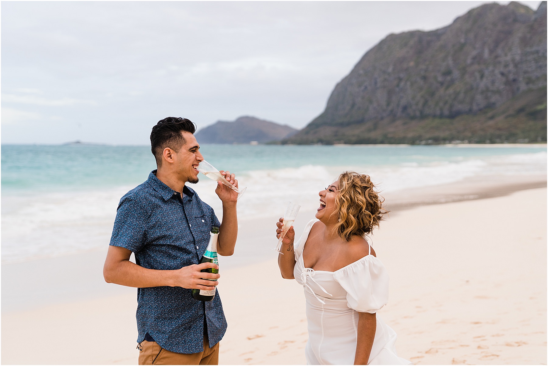 couple popping champagne for anniversary couples photo session in Hawaii