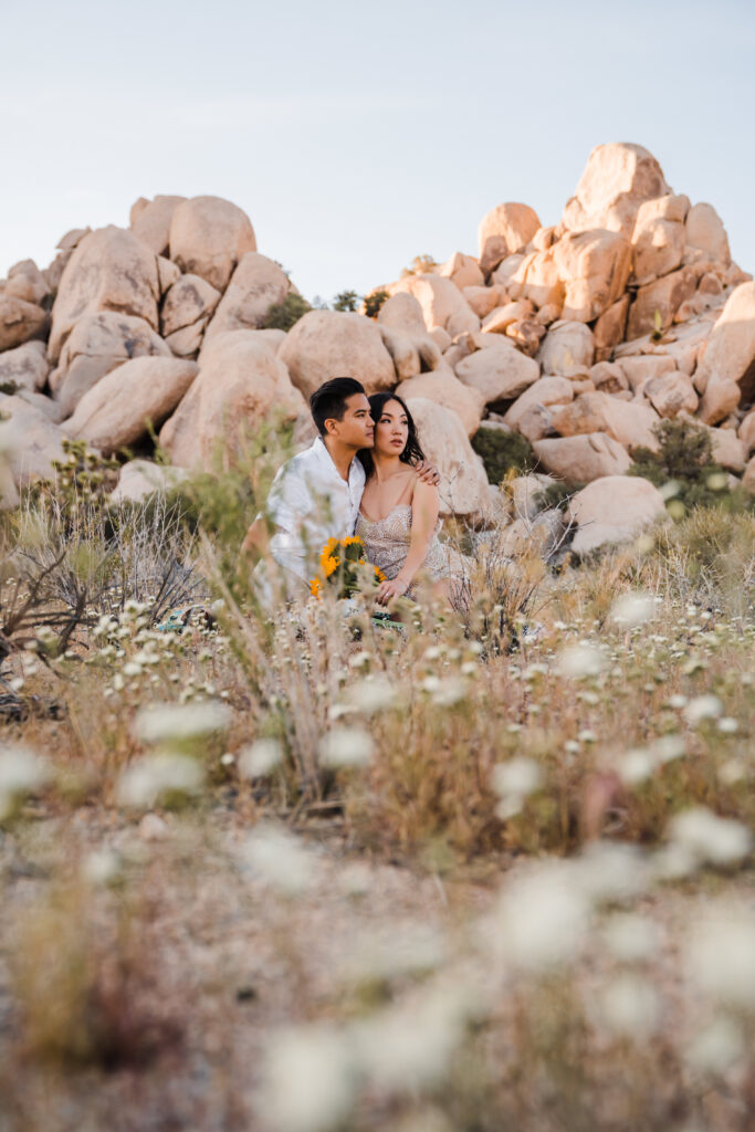 couple sitting in wildflowers in Joshua Tree national park
