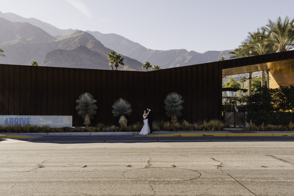 photo of bride and groom in front of ARRIVE hotel palm springs