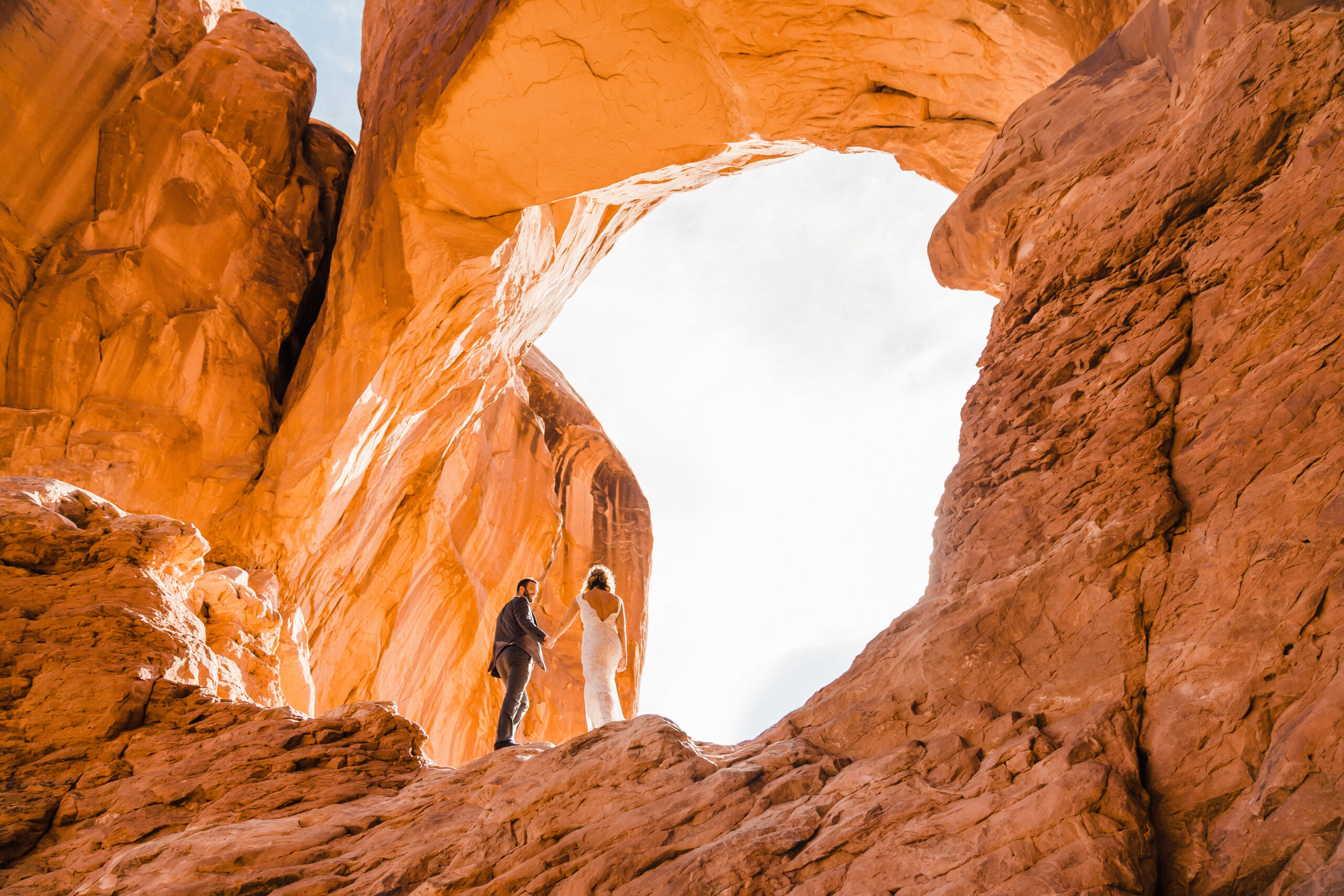 eloping couple exploring arch in moab utah
